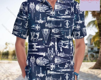 May include: A blue short-sleeved button-up shirt with a white outline pattern of various Star Wars spaceships. The shirt has a white collar and a button-up front.