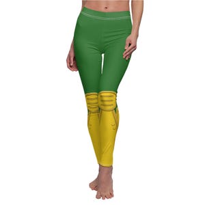 Puede incluir: Leggings verdes con rodilleras amarillas. Las leggings tienen un diseño deportivo.