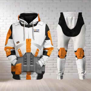 Może przedstawiać: Biały i pomarańczowy zestaw bluzy z kapturem i spodni. Bluza z kapturem ma szczegółowy wzór z pomarańczowymi akcentami, czarnym kapturem i szarym wzorem paska narzędziowego. Spodnie mają podobny wzór z pomarańczowymi nakolannikami i czarnymi akcentami.