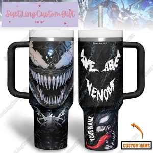 Könnte beinhalten: Ein schwarz-weißer Edelstahlbecher mit einem Venom-Motiv. Der Becher hat einen schwarzen Deckel und einen schwarzen Griff. Der Text "We are Venom" ist auf dem Becher aufgedruckt. Der Text "Tom Hardy" ist auf dem Becher aufgedruckt. Der Text "Your Name" ist auf dem Becher aufgedruckt. Der Text "Custom Name" ist auf dem Becher aufgedruckt.