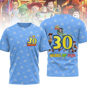 Könnte beinhalten: Ein blaues T-Shirt mit einem weißen Wolkenmuster. Die Vorderseite des Shirts hat ein Toy Story Logo und die Zahl 30 mit dem Text "30th Anniversary". Die Rückseite des Shirts hat eine große Zahl 30 mit dem Text "Toy Story" und "30 Years of Fun" mit Bildern von Figuren aus den Toy Story Filmen.