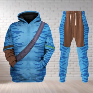 May include: A blue hoodie and matching pants set. The hoodie features a hood, a brown shoulder strap design, and a front pocket. The pants have a brown panel at the top and a drawstring. Both pieces have a blue wave pattern.