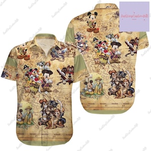 Puede incluir: Una camisa de botones de estilo vintage con un estampado de mapa de dibujos animados con Mickey Mouse y otros personajes de Disney. El mapa está etiquetado con nombres como "Fairy Hills", "Frog Dev", "Parrot's Bay" y "Sea".