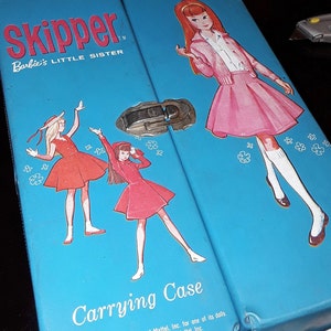 May include: A blue metal carrying case for dolls with a latch and a Skipper Barbie logo. The case has a white inscription that reads "Carrying Case" and "Mattel, Inc. for one of its dolls."