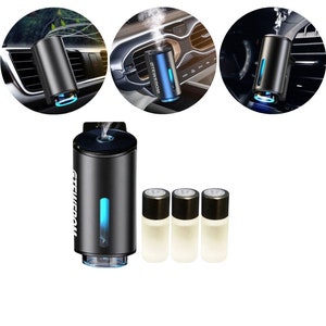May include: A black car air freshener with a blue light and a white label that says "STEWEROM". The air freshener is attached to a car air vent. Three small bottles of essential oil are included.