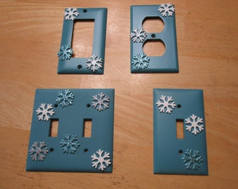 Set of 4 outlet covers in teal with sparkly snowflakes