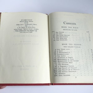 May include: A close-up of the contents page of a book titled "The Golden Thread" by Charles Dickens. The book is divided into two parts: Book the First, Recalled to Life, and Book the Second, The Golden Thread. The page lists the chapters and their corresponding page numbers.
