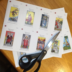 May include: A set of tarot cards with images of the Major Arcana. The cards are printed on white paper with black text and are cut out with scissors. The cards are numbered 0001 through 0009.