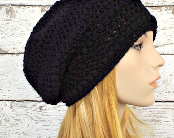 Op de afbeelding: Een zwarte gebreide beanie met een slouchy pasvorm. De beanie is gemaakt met een textuurpatroon.