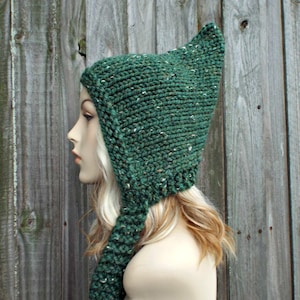 May include: A green knitted hat with a long, pointed tail. The hat has a flecked texture and is made with a soft yarn.