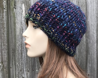 May include: A dark blue beanie with multi-colored flecks. The beanie is knit and has a slouchy fit.