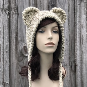 May include: A crocheted beige bear hat with long ties. The hat has large, floppy ears.