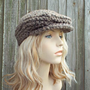 A chunky knit golf cap. This hat comes in 33 colors, shown here in barley, a light brown tweed. This hat fits an average adult and teen sized head of 20 to 23 inches.