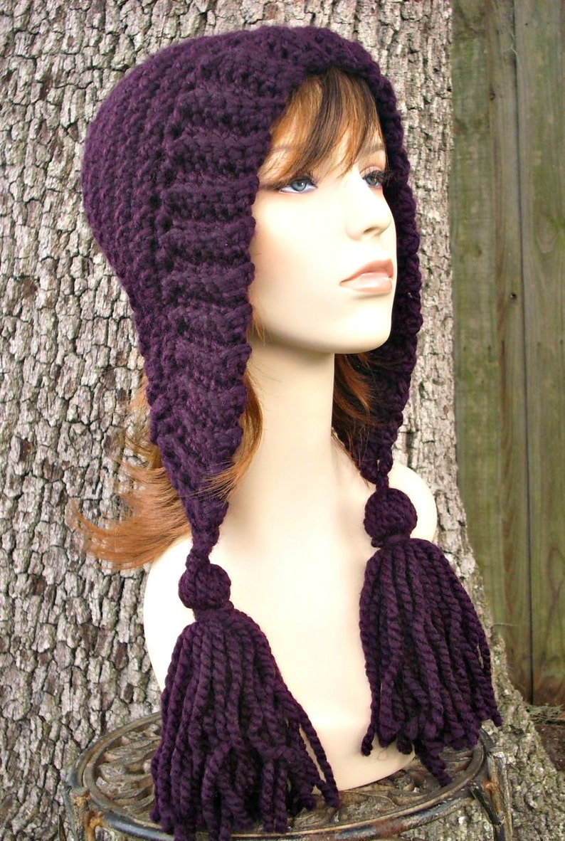 Puede incluir: Un gorro de punto morado con una capucha larga y puntiaguda y dos borlas largas. El gorro est&aacute; hecho de un hilo suave y grueso y tiene un dise&ntilde;o simple y cl&aacute;sico.