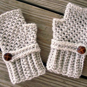 May include: A pair of beige crocheted fingerless gloves with brown button accents.