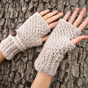 May include: A pair of beige crocheted fingerless gloves with a button on one glove.