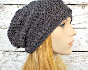 Op de afbeelding: Een grijze gebreide beanie met een slouchy pasvorm. De beanie is gemaakt met een textuurpatroon.