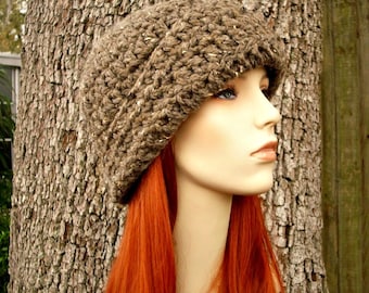 Puede incluir: Un gorro de punto marrón con un patrón texturizado. El gorro lo lleva un maniquí con el pelo largo y rojo brillante.