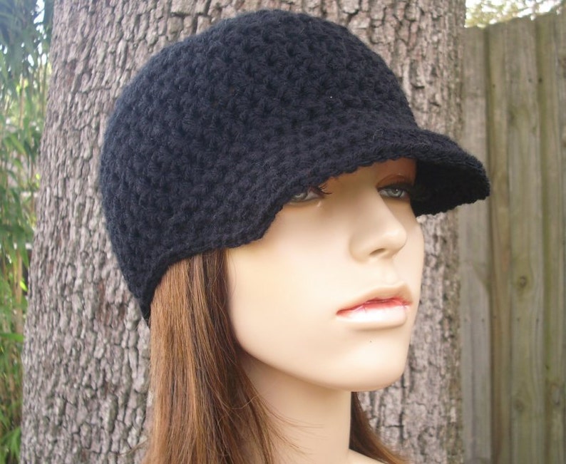 A fitted light weight crochet beanie with attached brim visor in black. This hat fits an average adult and teen head size of 20 to 23 inches.