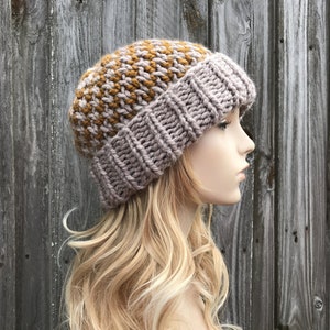 May include: A knitted beanie hat with a brown and gray color block pattern. The hat is made with a chunky yarn and has a slouchy fit.