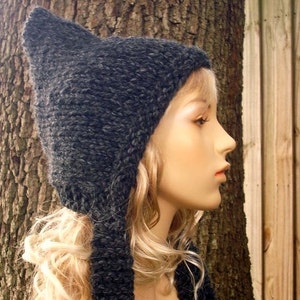 May include: A black knitted cat ear hat with a long tail. The hat is made of a soft, fuzzy yarn.