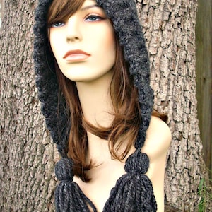 May include: A gray hooded hat with long tassels. The hat is made of a soft, fuzzy yarn and has a simple, classic design.