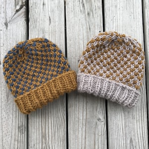 Könnte beinhalten: Zwei gestrickte Mützen mit einem karierten Muster. Eine Mütze ist braun und blau, die andere ist braun und grau.