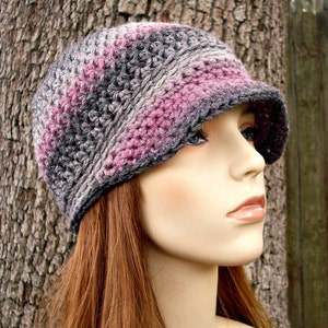 May include: A crocheted hat with a pink and gray color scheme. The hat has a wide brim and a slouchy fit.