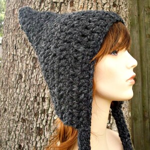 May include: A gray crocheted hat with a long pointed flap in the back. The hat is made with a textured stitch and has a simple design.