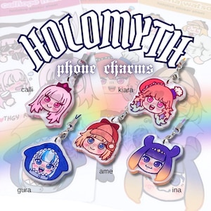 May include: Clear acrylic phone charms featuring anime-style character designs. The charms include characters named Calli, Kiara, Gura, Ame, and Ina. Each charm has a silver-colored chain for attachment. The text "HOLOMYTH" and "phone charms" are displayed.