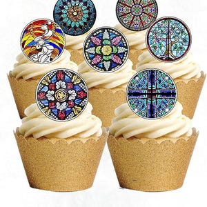 May include: Cupcakes with white frosting and decorative toppers featuring stained glass designs. The toppers showcase various colorful patterns, including floral, geometric, and religious motifs. The cupcakes are in gold paper liners.