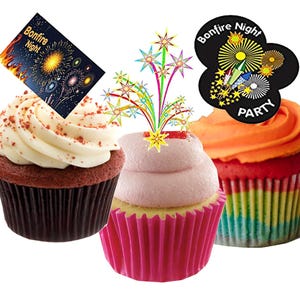 May include: Three cupcakes with decorative toppings. One cupcake has white frosting with a Bonfire Night card. Another has pink frosting with a firework topper. The third has orange frosting and a Bonfire Night Party topper.