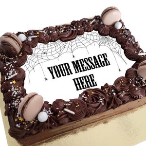 May include: A rectangular chocolate cake with dark brown frosting, decorated with piped swirls, sprinkles, and macarons. The center features a white space with a spiderweb design and the text "YOUR MESSAGE HERE".