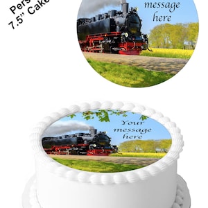 May include: A 7.5 inch round edible cake topper featuring a black steam engine train traveling through a green field with yellow flowers. The text "Your message here" is printed on the topper.
