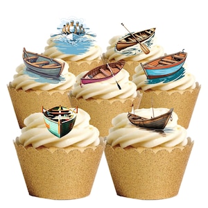 Peut inclure: Des cupcakes décorés sur le thème des bateaux. Chaque cupcake est recouvert d'un tourbillon de glaçage blanc et d'une image de bateau. Les bateaux sont de couleurs et de styles variés, y compris des barques et un bateau avec une équipe d'aviron.