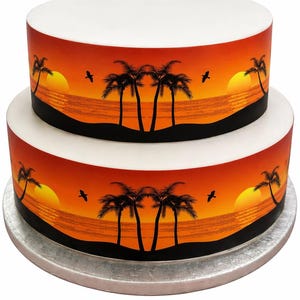 Peut inclure: Gâteau à deux étages avec un motif de coucher de soleil. Le gâteau présente un dessus blanc et une scène de coucher de soleil orange et jaune vif avec des palmiers et des oiseaux. Le gâteau repose sur un présentoir à gâteau argenté.