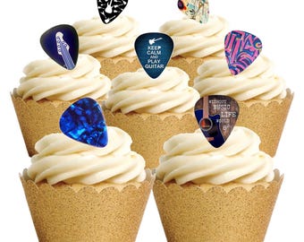 May include: Six cupcakes with white frosting and guitar pick toppers. The guitar picks have various designs, including a blue pick with a guitar graphic, a pick with the text "KEEP CALM AND PLAY GUITAR", and a pick with the text "WITHOUT MUSIC LIFE WOULD B".