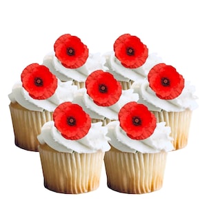Op de afbeelding: Zeven cupcakes met witte frosting en rode klaproosversieringen. De cupcakes hebben een lichtbruine papieren basis. De klaprozen hebben een donker centrum en helderrode bloemblaadjes.