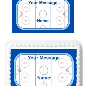 May include: A blue and white hockey rink cake topper with the text "Your Message" and "Name" on it. The topper is designed for a rectangular cake.