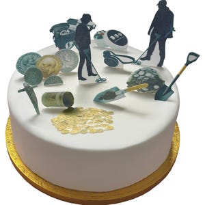 Könnte beinhalten: Ein weißer Kuchen, der mit einem Metalldetektionsthema verziert ist. Der Kuchen ist mit verschiedenen Metalldetektionsgeräten verziert, darunter ein Metalldetektor, eine Schaufel und ein Eimer mit Münzen. Außerdem sind mehrere Münzen um den Kuchen herum verstreut.