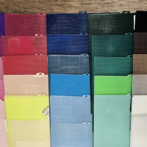 May include: A collection of rectangular plastic mesh sheets arranged in a grid, featuring a wide variety of solid colors including purple, pink, red, blue, green, brown, beige, gray, black, and white, each with a uniform grid pattern.