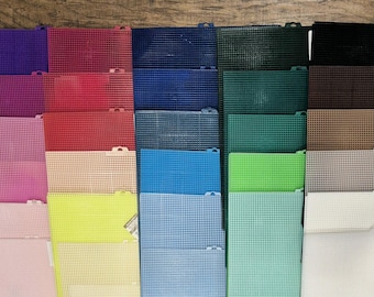 May include: A collection of rectangular plastic mesh sheets arranged in a grid, featuring a wide variety of solid colors including purple, pink, red, blue, green, brown, beige, gray, black, and white, each with a uniform grid pattern.