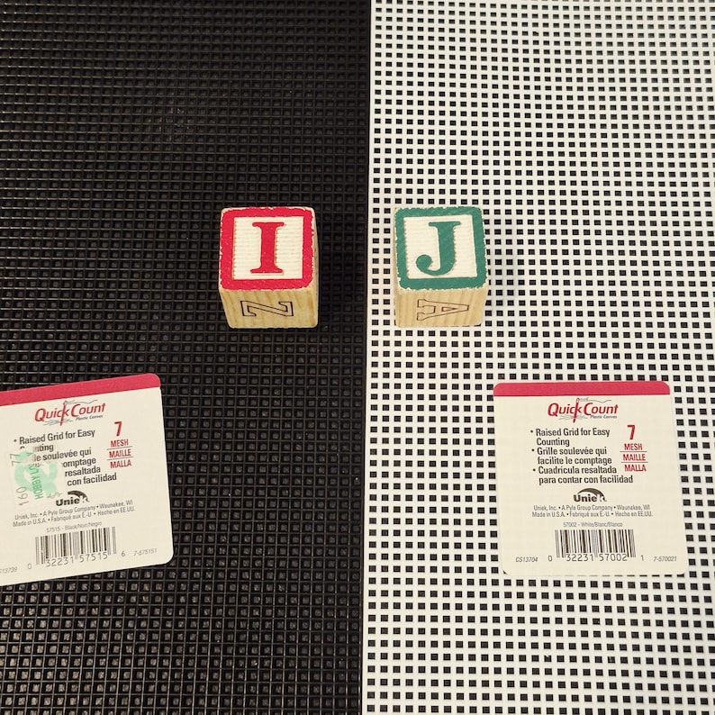 May include: Two wooden alphabet blocks, one with a red-bordered letter I and one with a green-bordered letter J, placed on black and white plastic mesh sheets. Each sheet includes a Quick Count label with text about the 7 mesh grid.