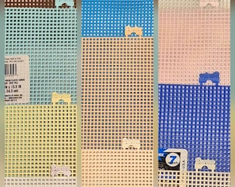 May include: A collection of rectangular plastic canvas sheets in various colors including brown, light blue, yellow, white, orange, and tan. Each sheet features a grid pattern and a small Darice brand tab. One sheet shows a label with 13.5 inches.