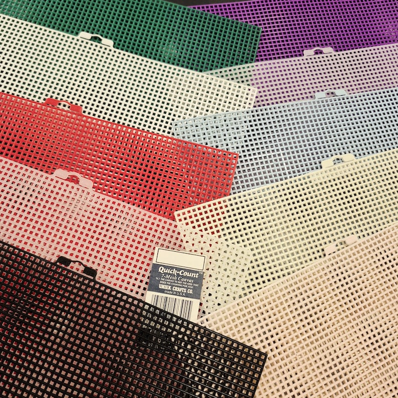 May include: A collection of rectangular plastic mesh sheets in various colors including green, purple, white, light blue, red, pink, beige, and black. Each sheet features a grid pattern and a small tab. A label reads Quick-Count 7-Mesh Canvas.