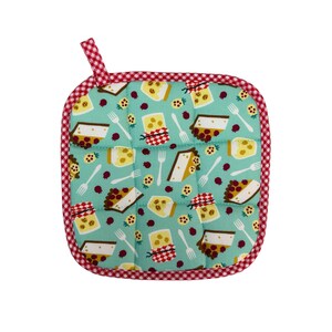 May include: Square, quilted pot holder with a teal background and a repeating pattern of cheesecake slices, forks, and berries. The pot holder has a red and white checkered border and a loop for hanging.