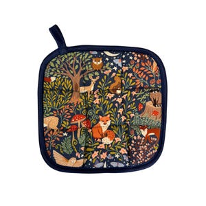 May include: Square navy blue pot holder with a loop for hanging. The fabric features a whimsical forest scene with foxes, owls, deer, mushrooms, and foliage in shades of orange, pink, and green. The pot holder is trimmed with a dark blue border.