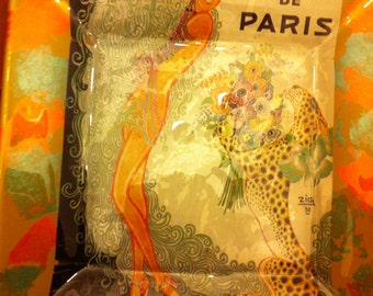 May include: A vintage-style ashtray with a colorful image of a woman in a feathered headdress and a leopard. The text "Casino de Paris" is printed on the ashtray.