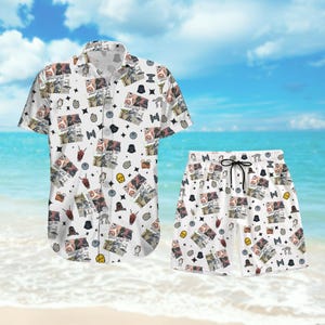May include: White button-down short-sleeve shirt and matching shorts set. The set features a repeating pattern of Star Wars characters and symbols. The shorts have a black drawstring. The set is displayed on a beach.