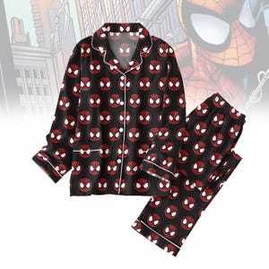 May include: Black pyjama set with a repeating pattern of Spider-Man's mask in red and white. The long-sleeved top has a button-down front and white trim. The matching trousers have an elasticated waistband and white trim.